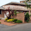 The driveway and entrance of a modern brick house with a privacy wall shielding a courtyard.