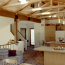 A kitchen and dining area with vaulted ceiling, exposed beams, and lots of natural light.